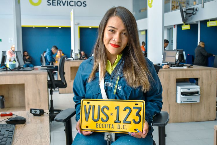 Analista de la Ventanilla Única de Servicios sostiene una placa de carro matriculada en Bogotá. - Foto: Valentina Bachiller © Consorcio Circulemos Digital, 2026