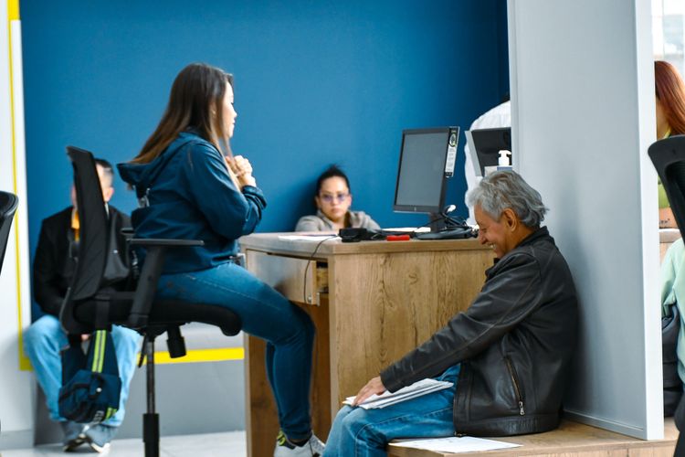 Persona mayor sonríe mientras realiza un trámite de tránsito y transporte en la Ventanilla Única de Servicios en Bogotá - Foto: Valentina Bachiller © Consorcio Circulemos Digital, 2025