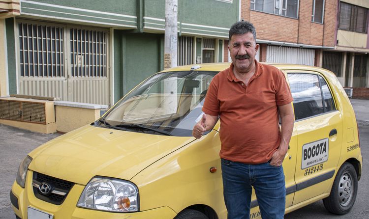 Taxista sonríe al lado de su vehículo - Foto: Felipe Rocha © Consorcio Circulemos Digital, 2026