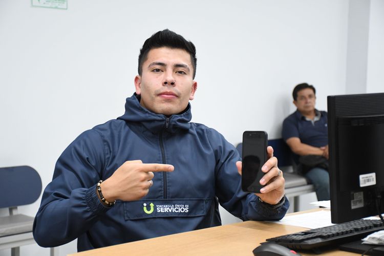 Analista de la Ventanilla Única de Servicios señala el celular - Foto: Felipe Rocha © Consorcio Circulemos Digital, 2024