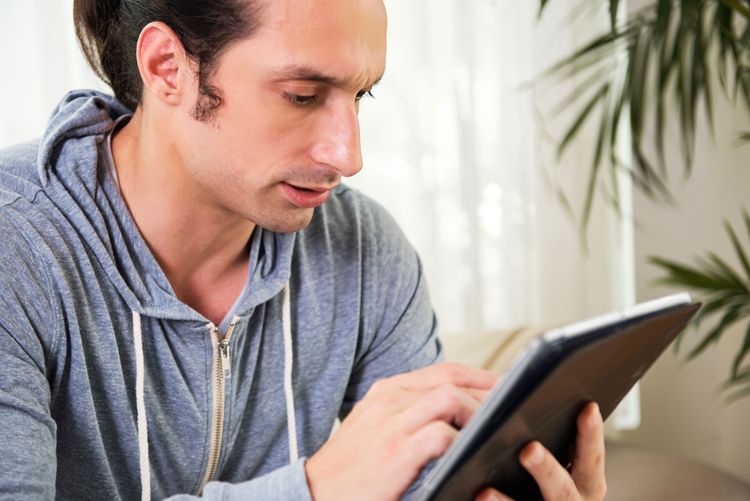 Hombre en casa usando su tablet – Imagen tomada de internet