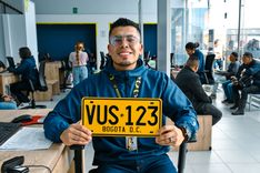 Analista de la Ventanilla Única de Servicios sostiene placa vehicular matriculada en Bogotá - Foto: Valentina Bachiller © Consorcio Circulemos Digital, 2026