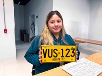 Analista de la Ventanilla Única de Servicios sostiene la placa de un vehículo matriculado en Bogotá - Foto: Valentina Bachiller © Consorcio Circulemos Digital, 2026