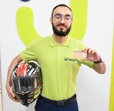 Analista de la Ventanilla Única de Servicios sostiene la licencia de conducción y un casco para conductor de motocicleta. - Foto: Felipe Rocha © Consorcio Circulemos Digital, 2023 