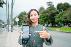 Mujer sostiene celular y señala la opción de Certificado de Libertad y Tradición con documento - Foto: Valentina Bachiller © Consorcio Circulemos Digital, 2025 